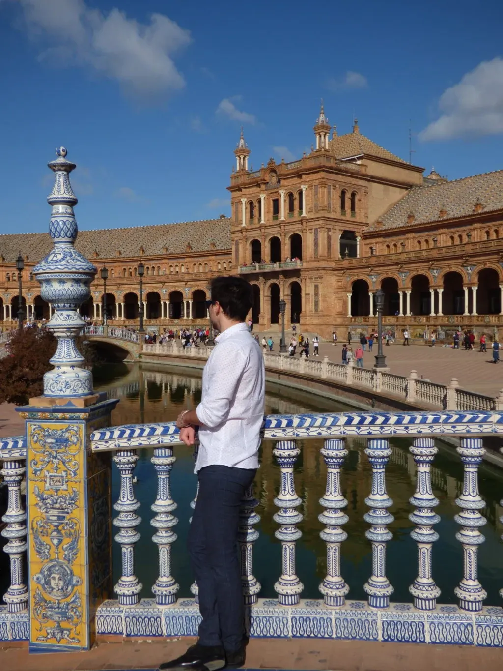 Man leaning on the balustrade facing the facade of the palace