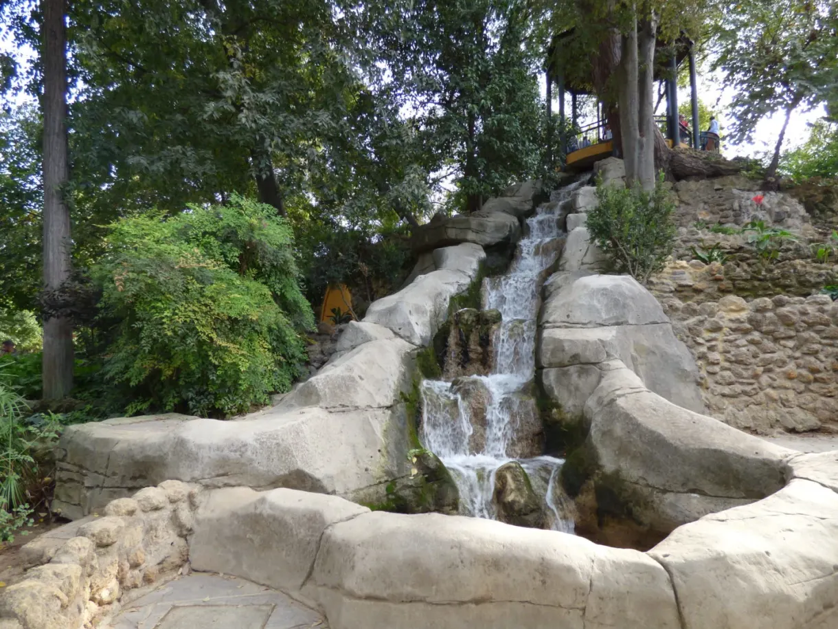 Artificial waterfall tumbling down a rock in the middle of the vegetation