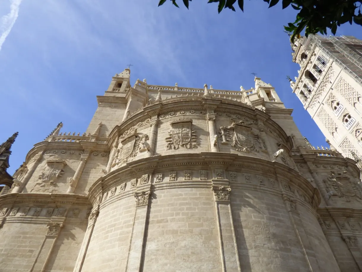 Stone buttresses and flying buttresses under a blue sky