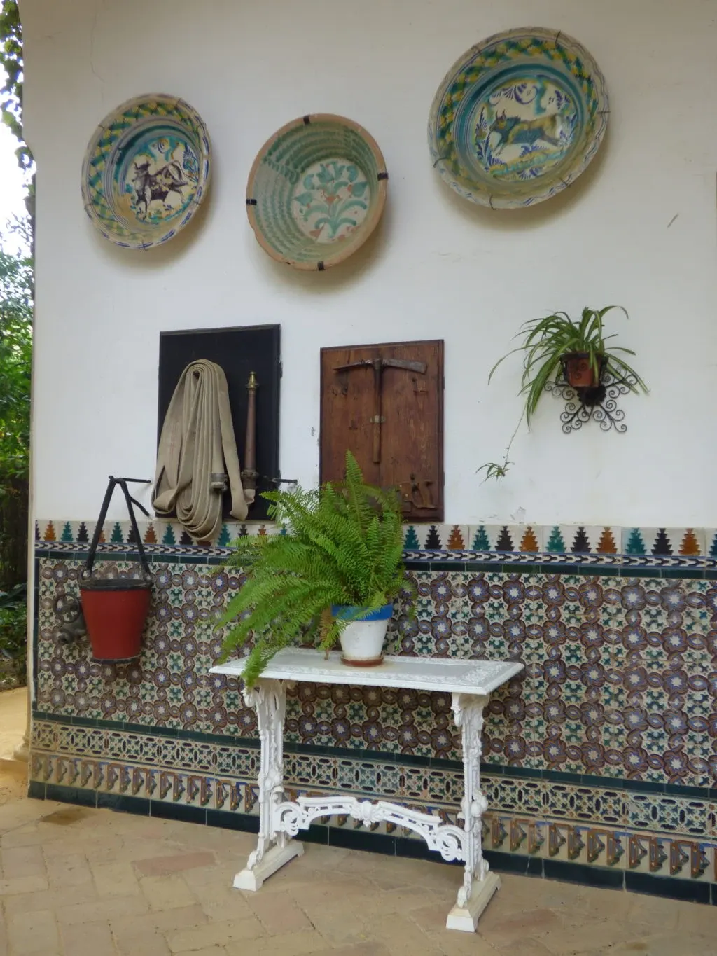 Antique plates hung above a white iron console table