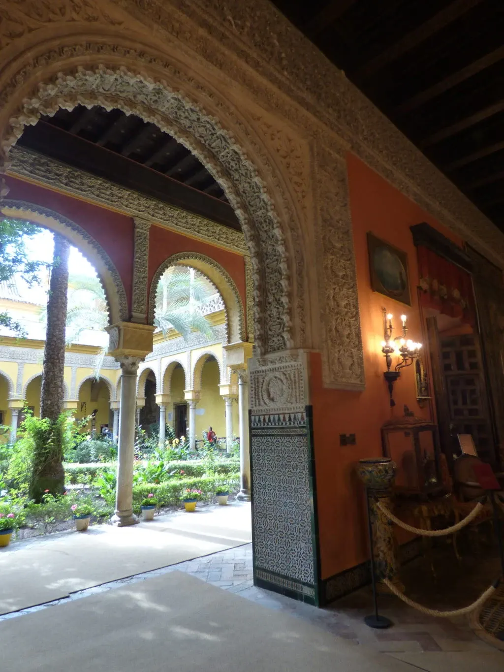Chiselled stucco arch between a red drawing room and the patio