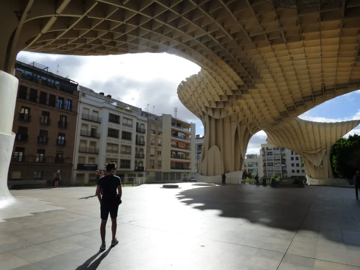 Esplanade shaded by the wooden structure, passer-by against the light