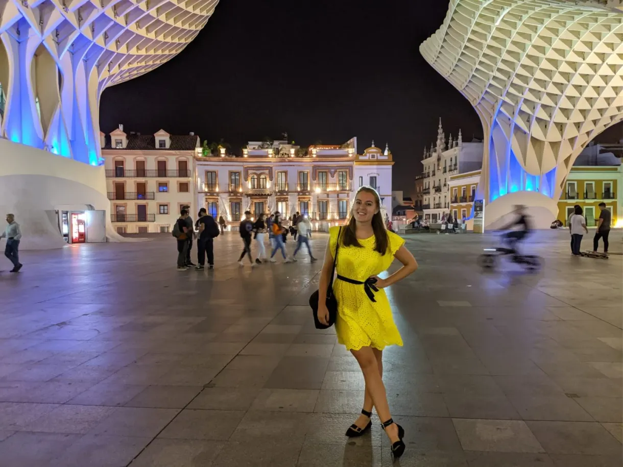 Woman in a yellow dress on the square lit up at night