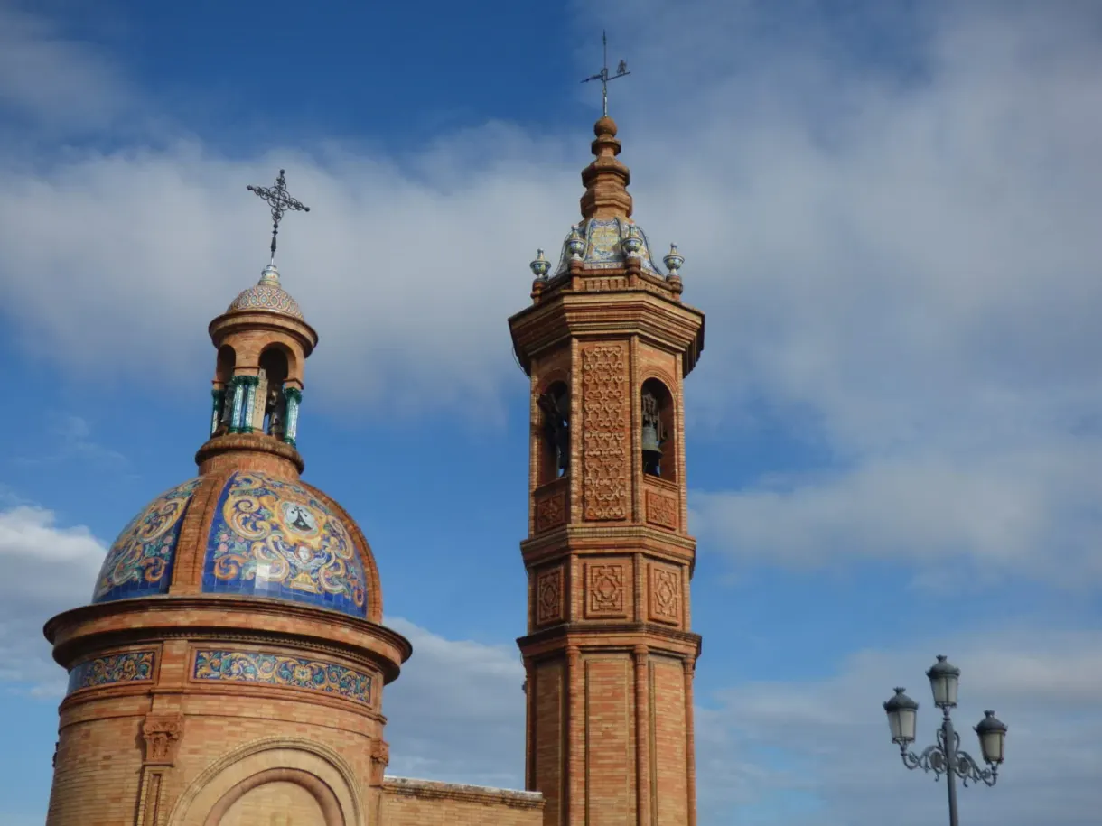 Ceramic bell tower and brick tower against a cloudy sky