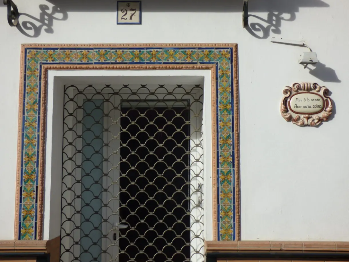 Doorway framed by flowered azulejos on a white facade