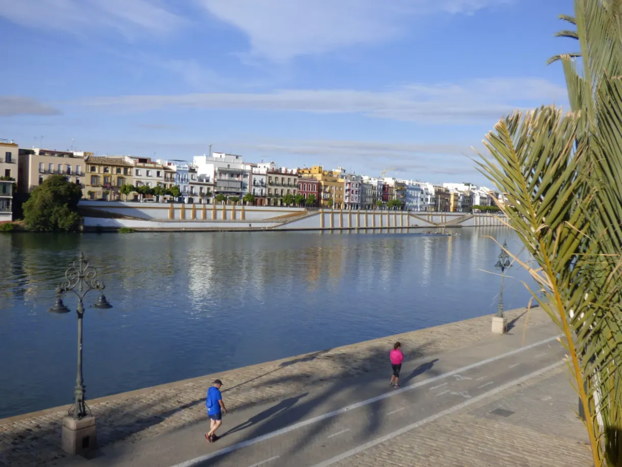 River quay and white bridge, walkers in the sun