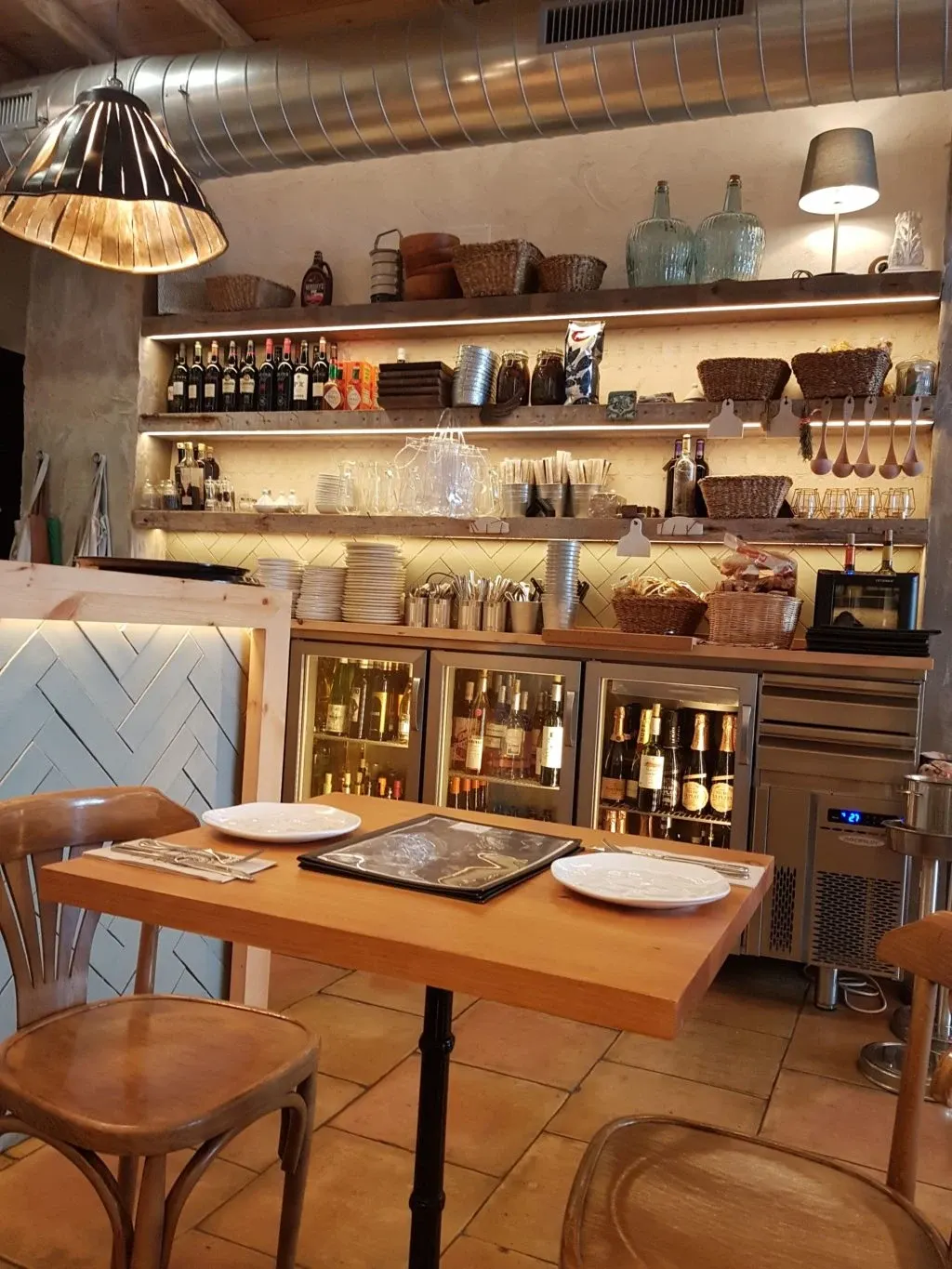 Wooden table and shelves of jars in a restaurant