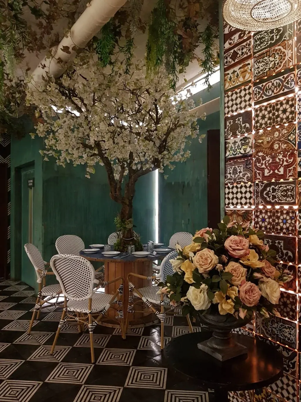 Dining room with a chequerboard floor, flowering tree and roses
