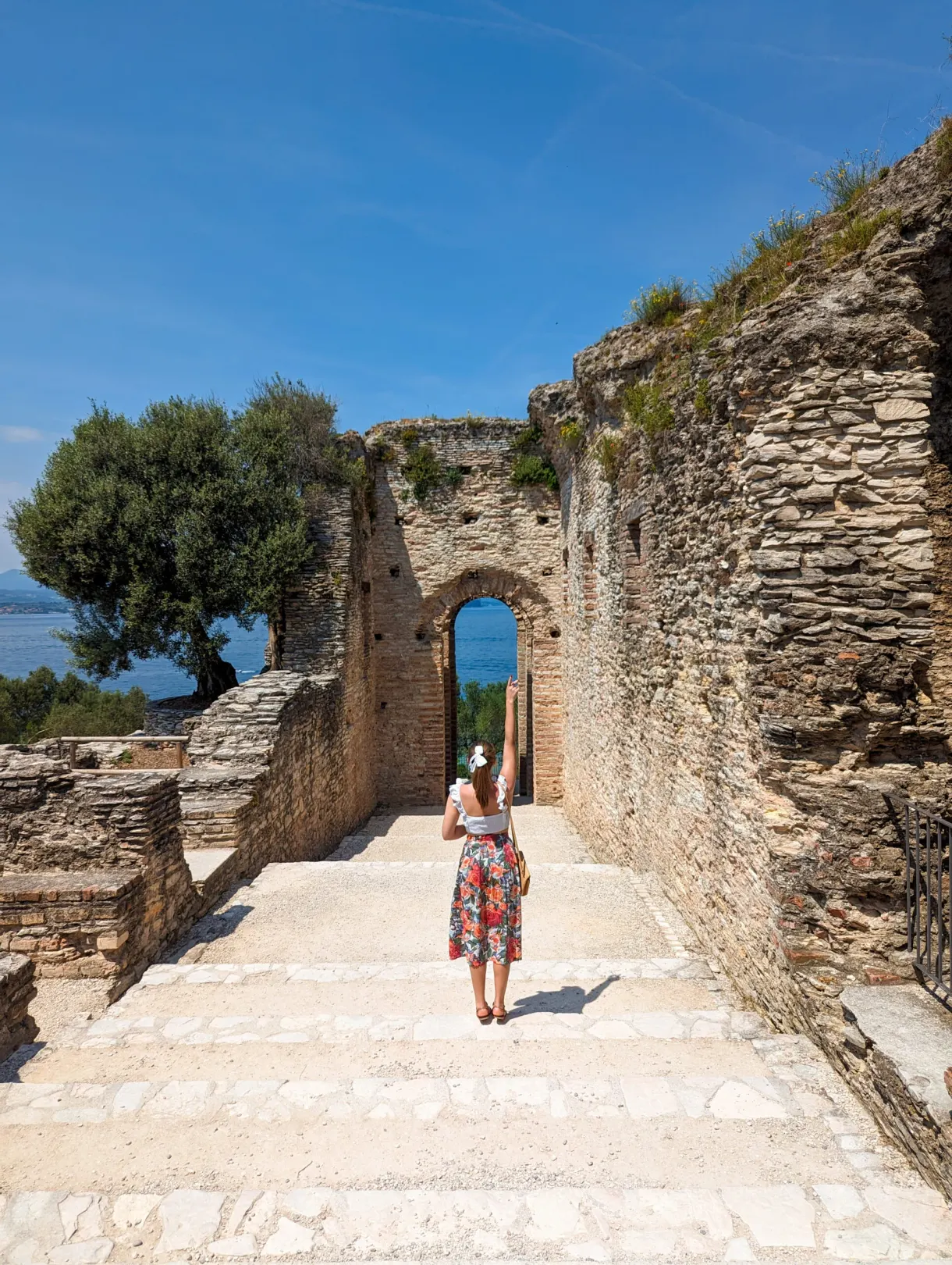 Femme gravissant l'escalier vers une arche des vestiges