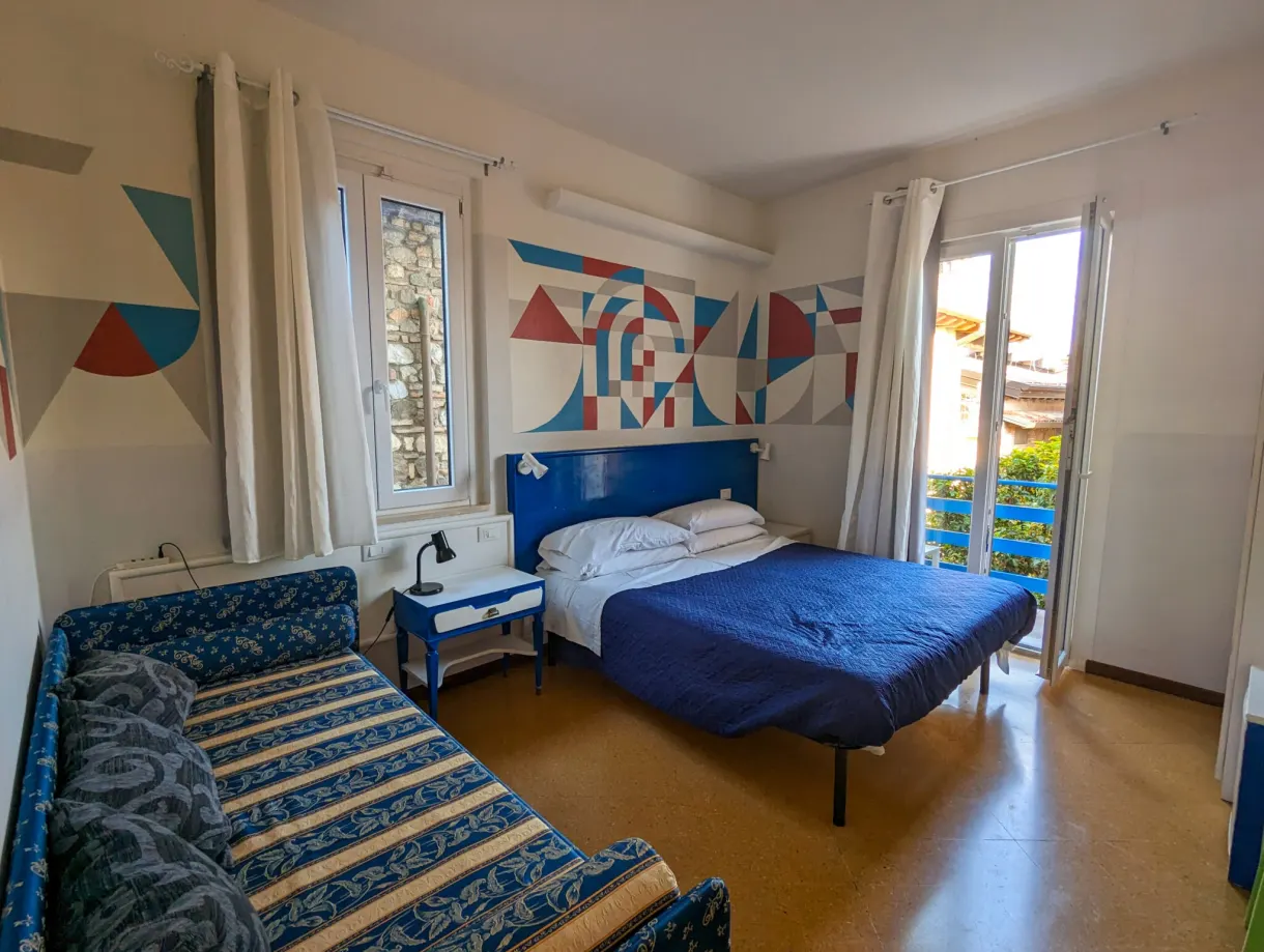 Chambre au lit bleu ouvrant sur un balcon
