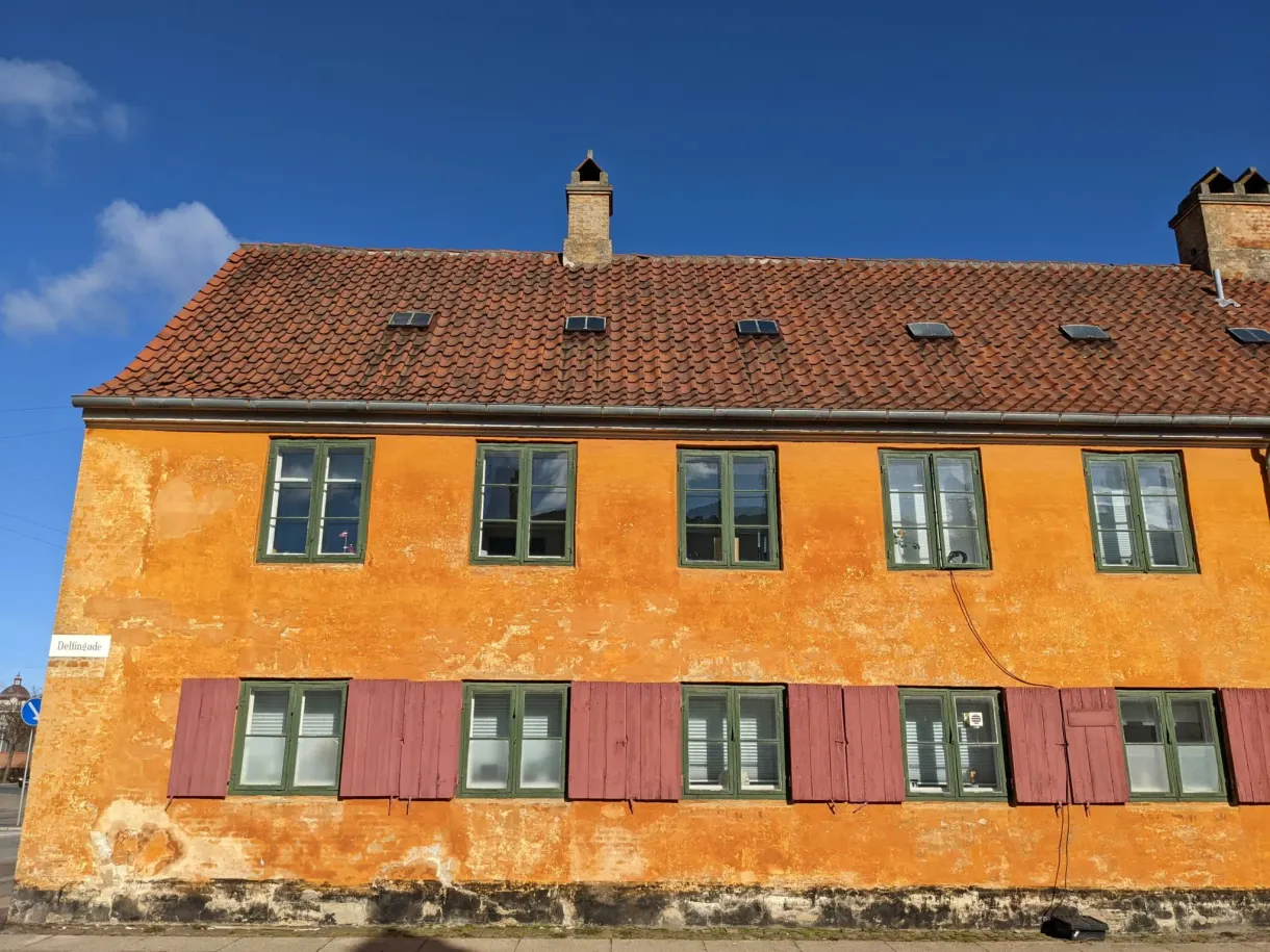 Pignon d'une maison ocre à volets rouges dans le quartier de Nyboder