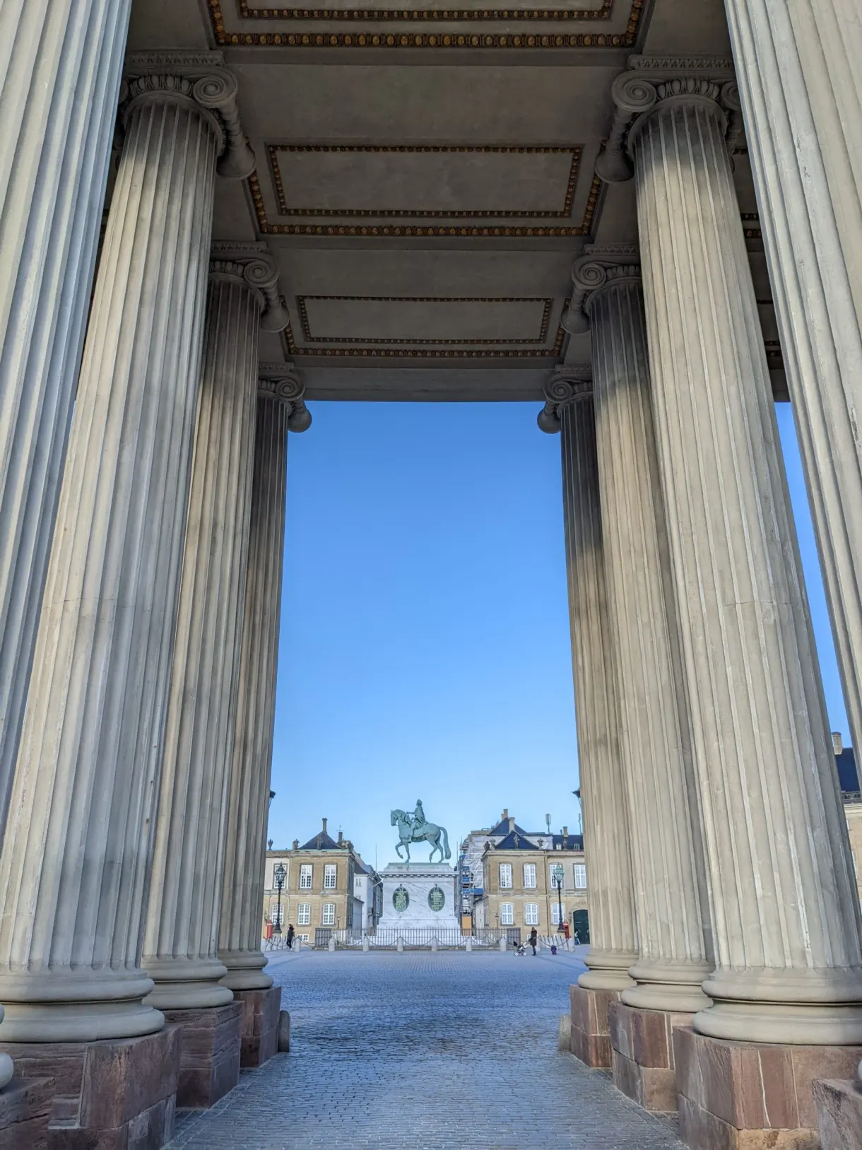 Colonnade de pierre encadrant la statue équestre de la place royale