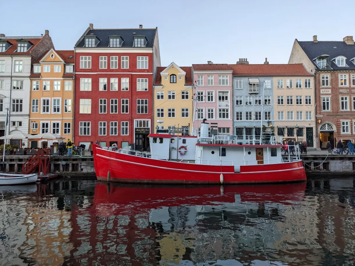 Bateau rouge à quai devant les hautes façades du canal