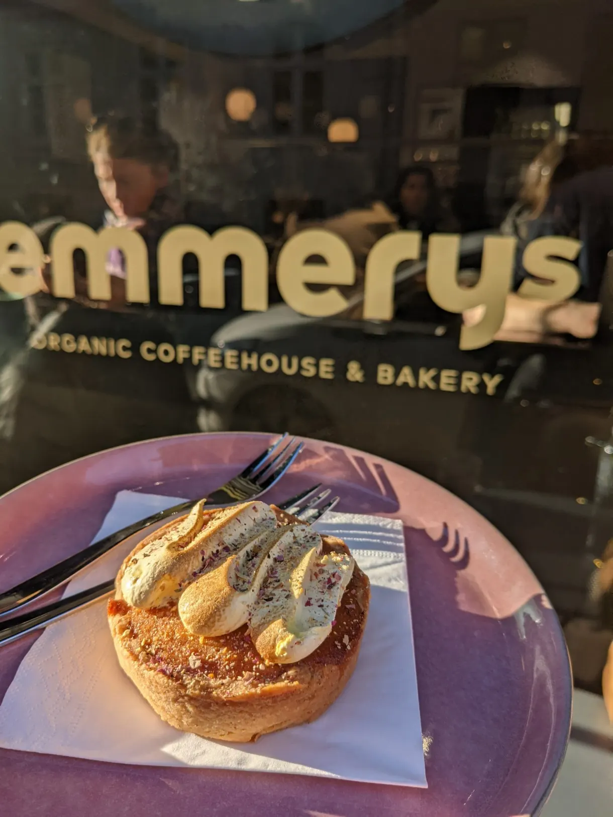 Viennoiserie garnie de banane dans une assiette rose derrière la vitrine