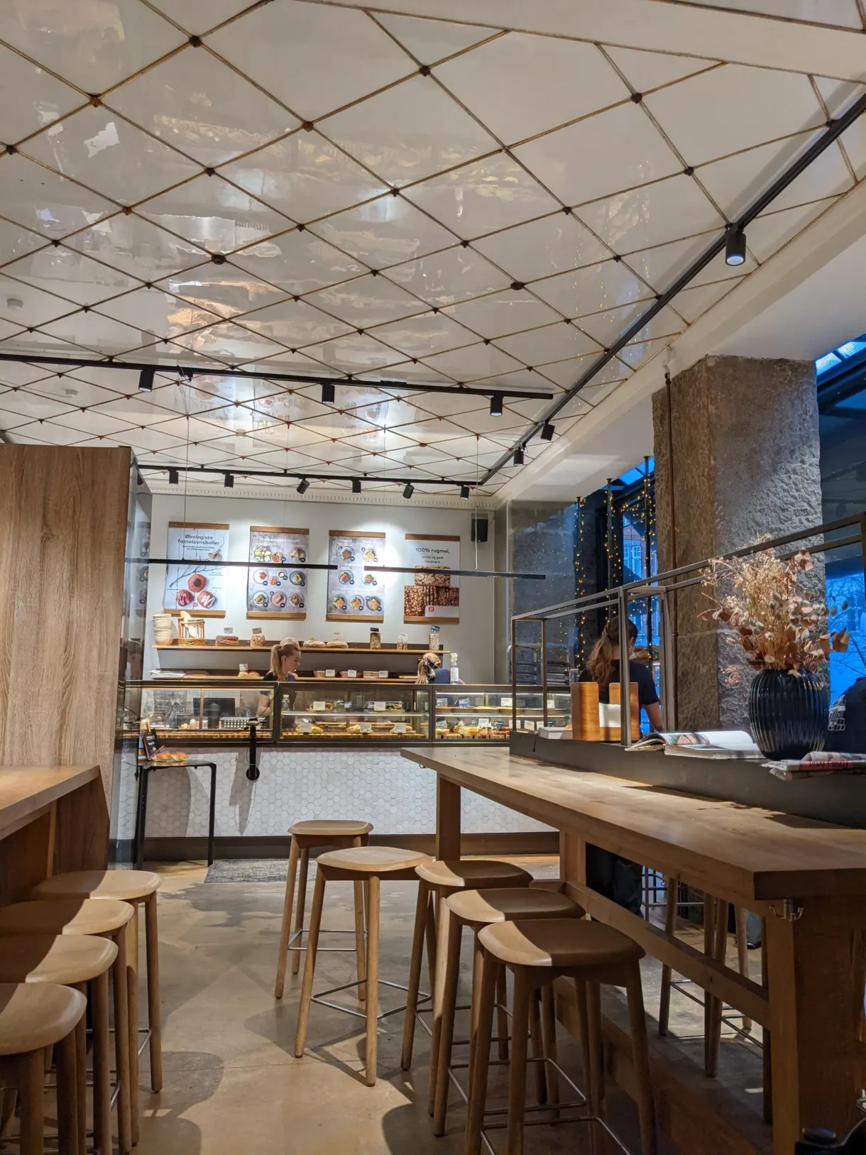 Salle de boulangerie aux tabourets de bois et longue table partagée