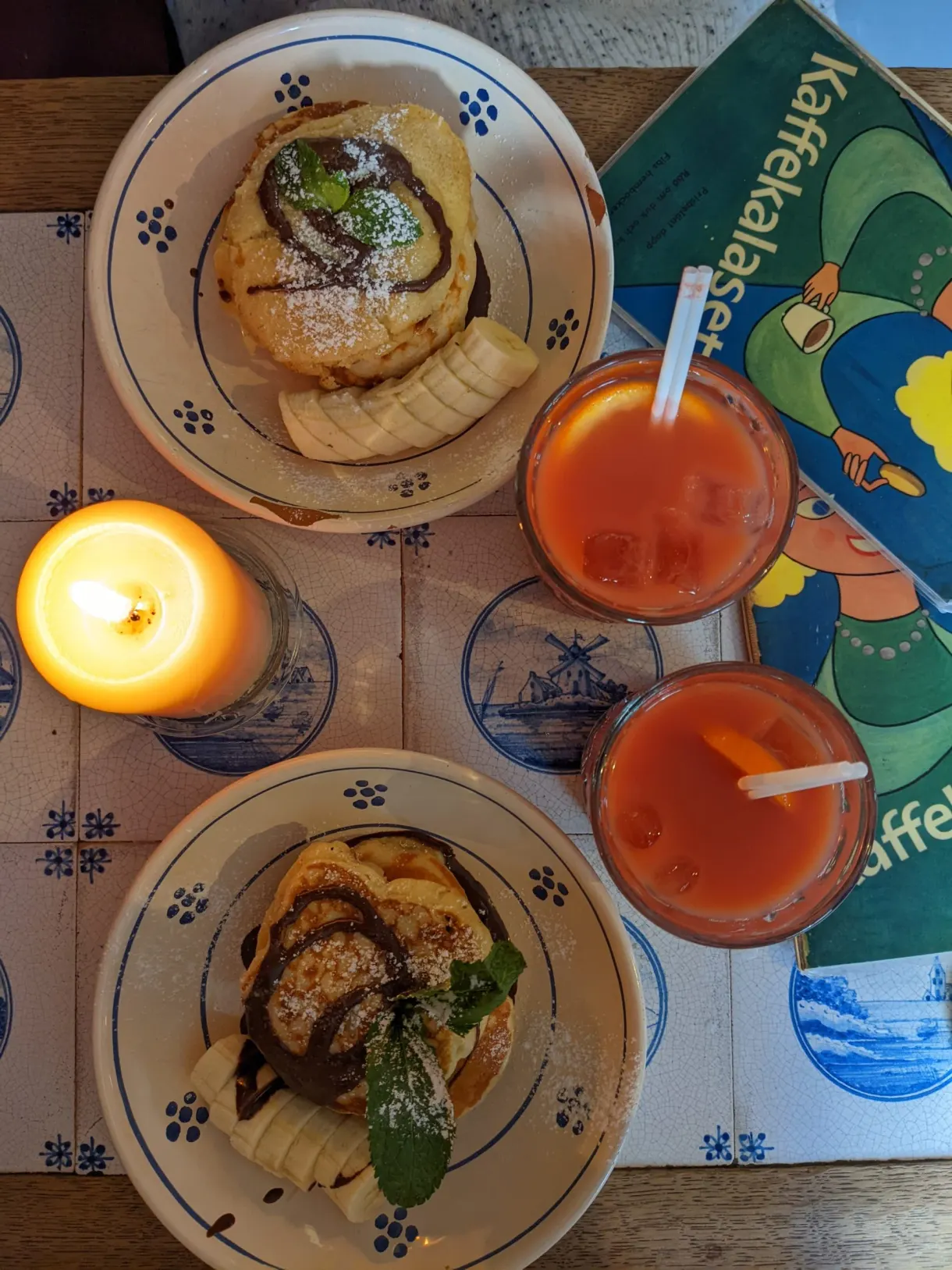 Roulés à la cannelle et jus de fruits sur une table à motifs bleus
