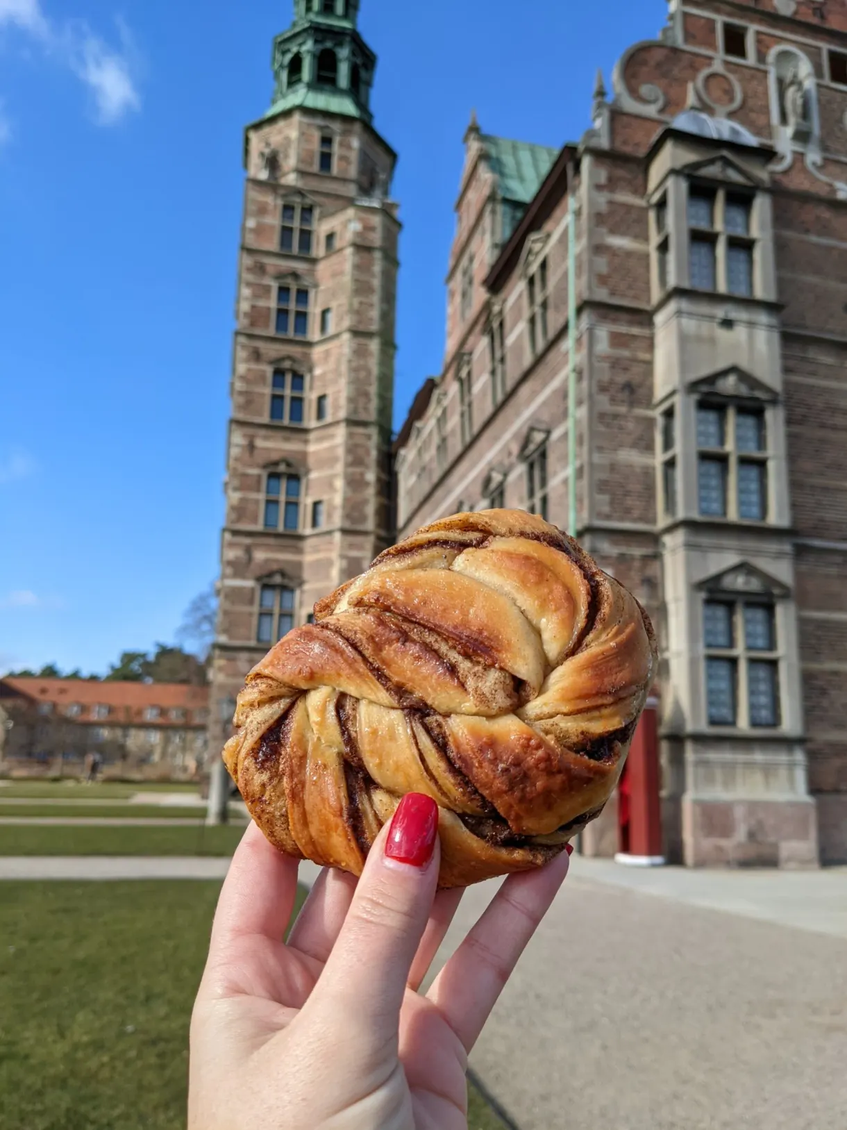 Brioche torsadée à la cannelle tenue devant le château de Rosenborg