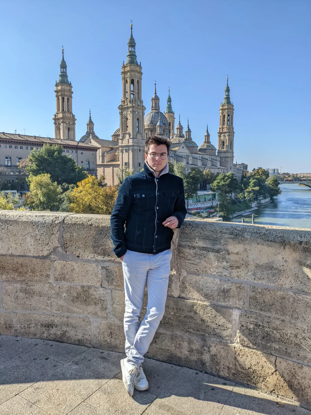 Man leaning on the bridge parapet in front of the basilica