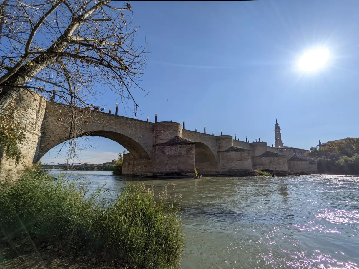 Stone arch against the light above the water