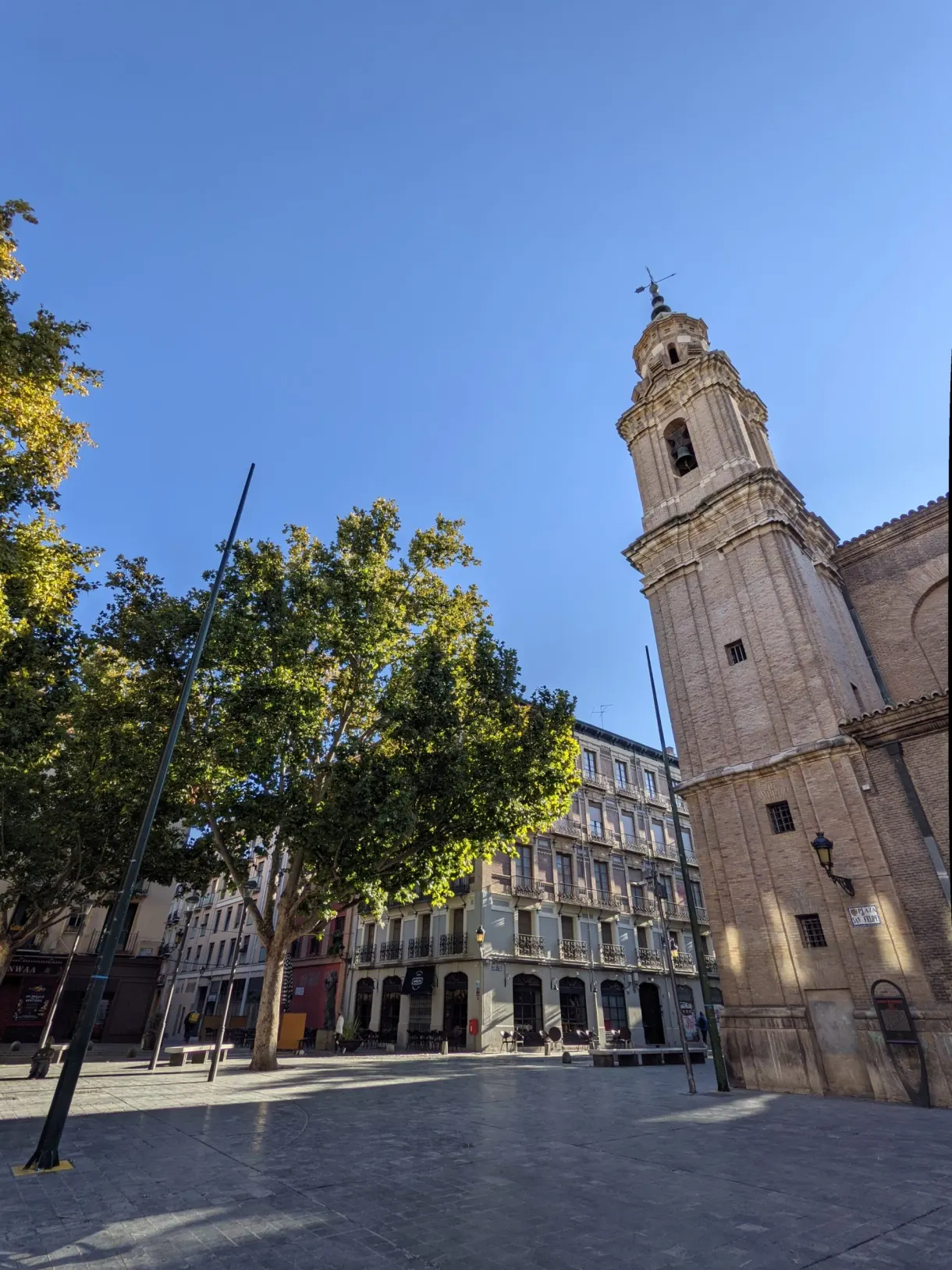 Empty square in the early morning at the foot of a bell tower