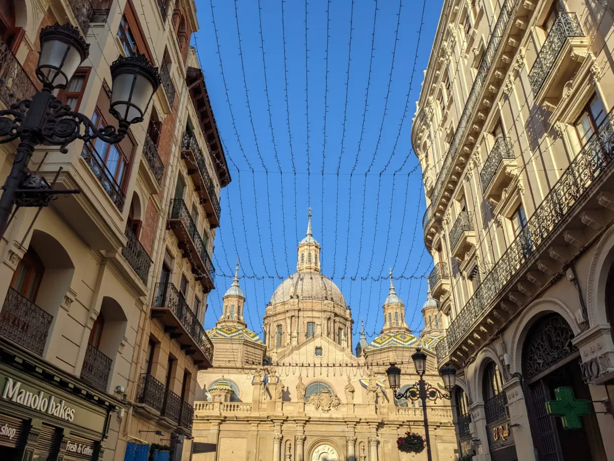 Garlands strung above a street towards the domes of El Pilar