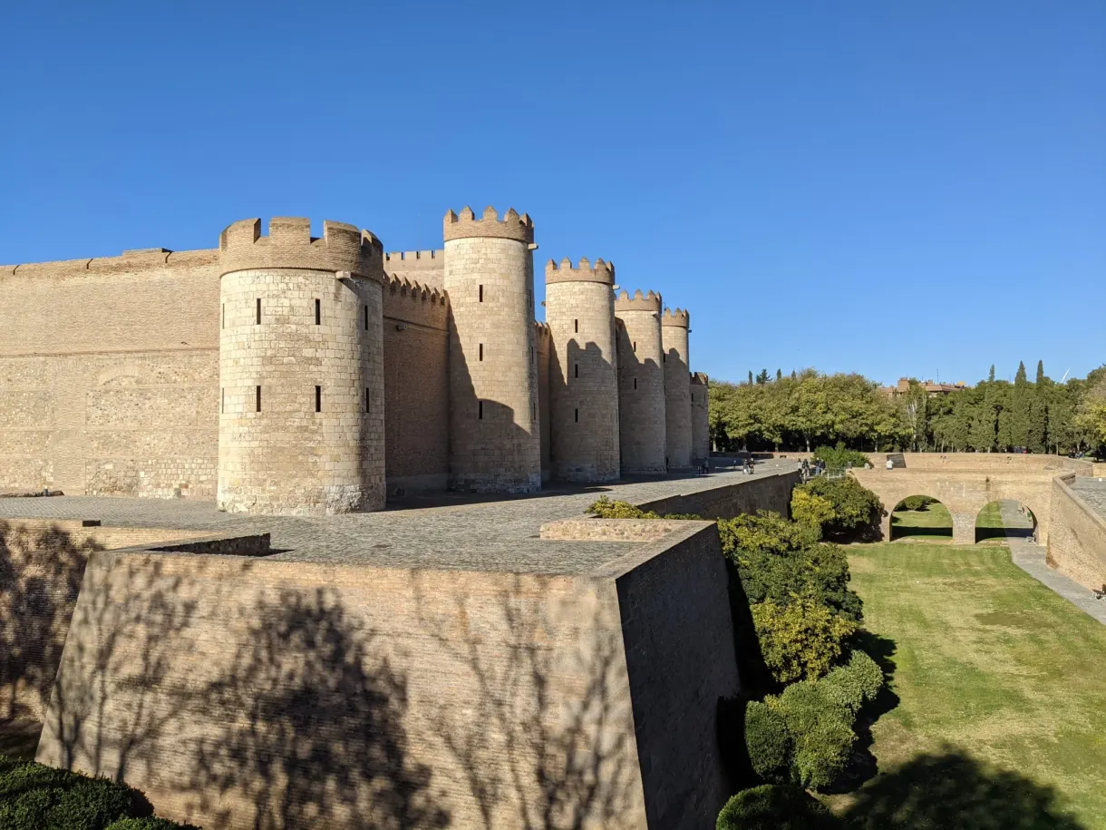 Towers of the Aljafería bordered by lawn and moat