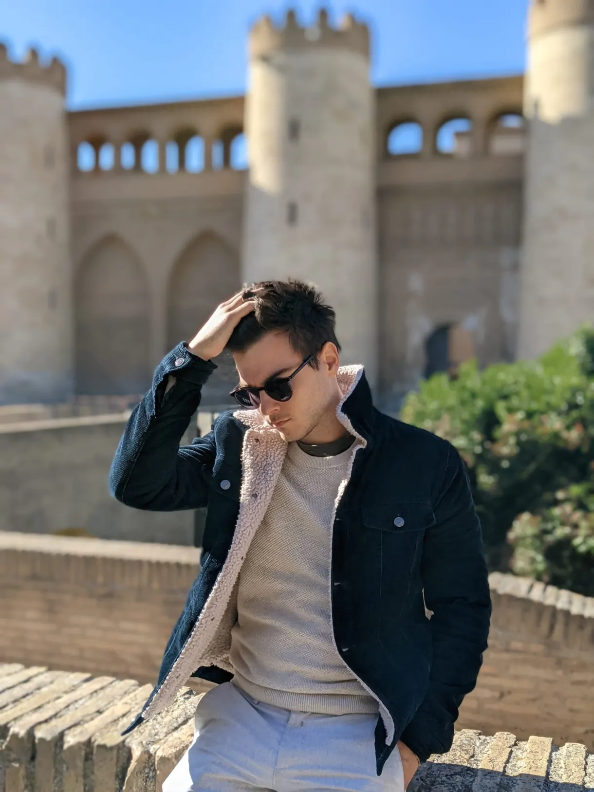Man in a dark jacket in front of the golden ramparts