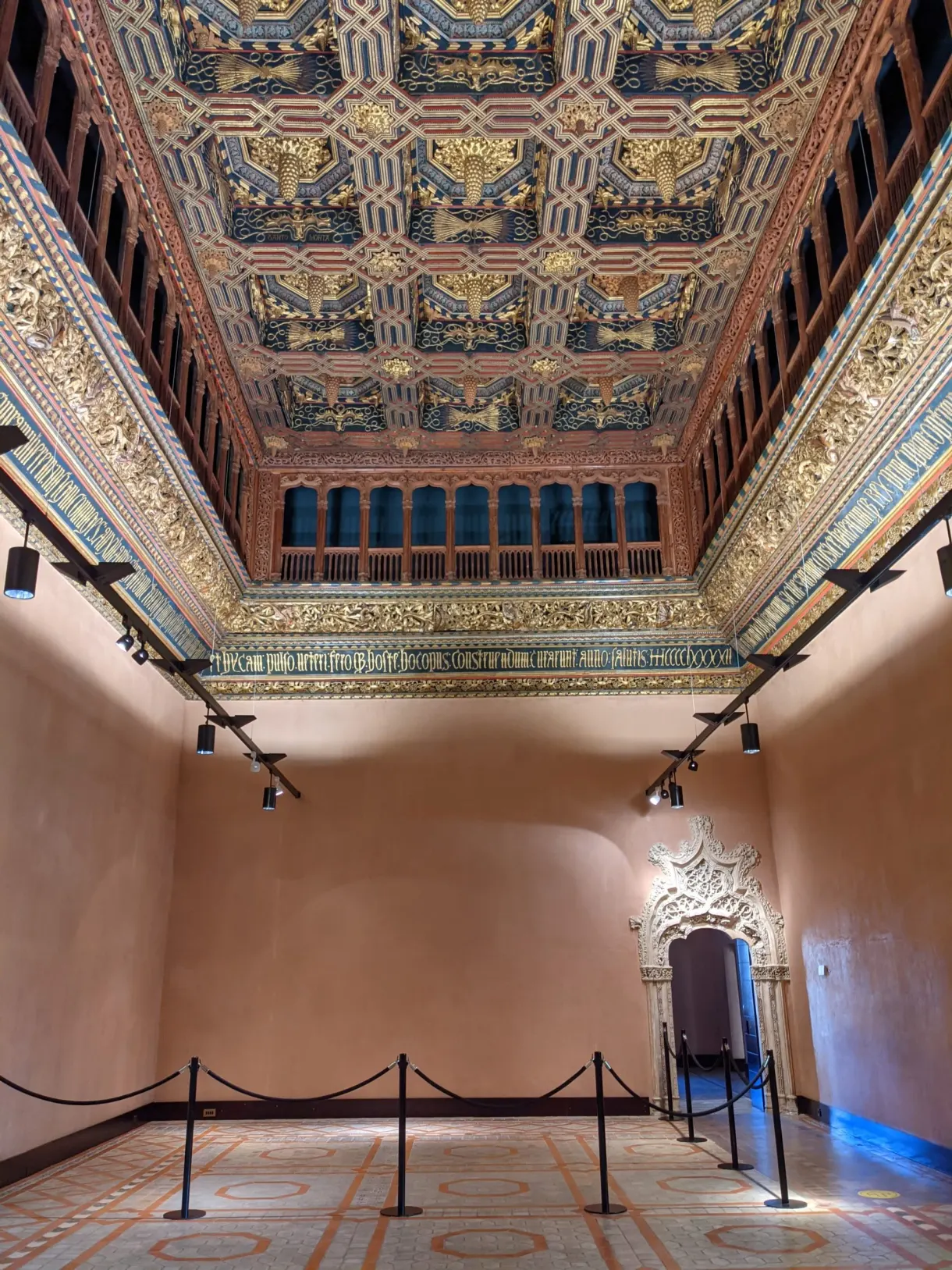 Gilded coffered ceiling of a room with pink walls