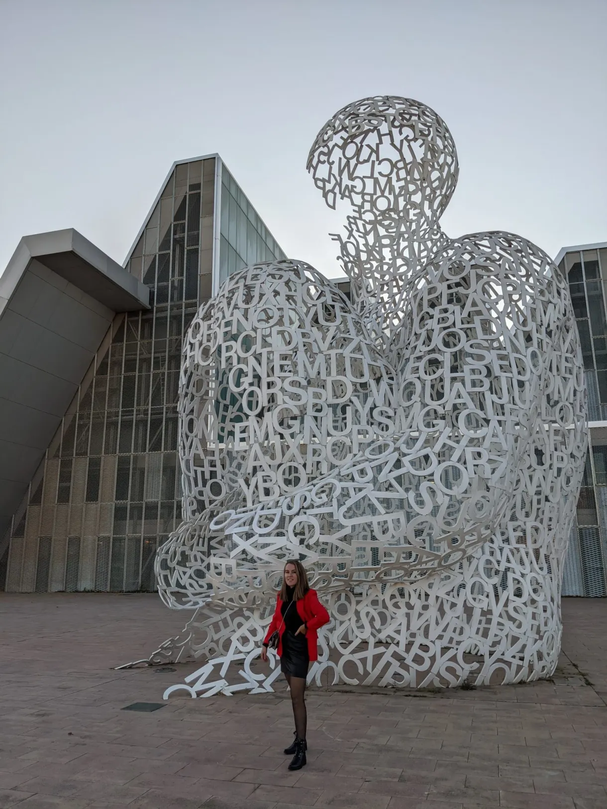 White openwork sculpture and passer-by in a red coat