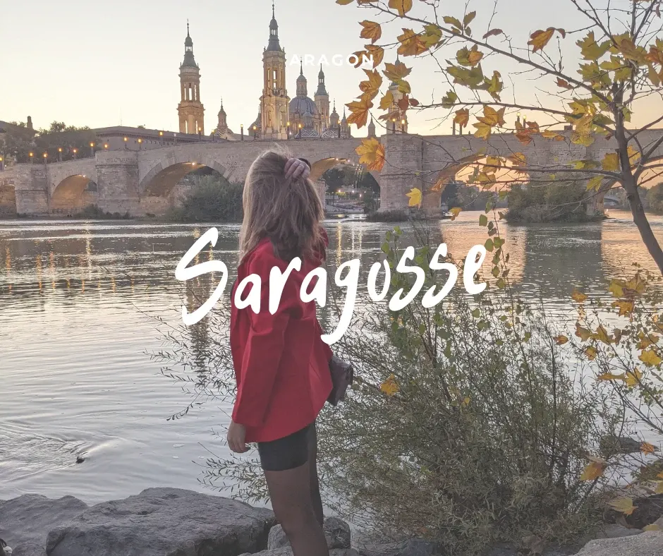 Woman in a red coat looking at the bridge in the evening