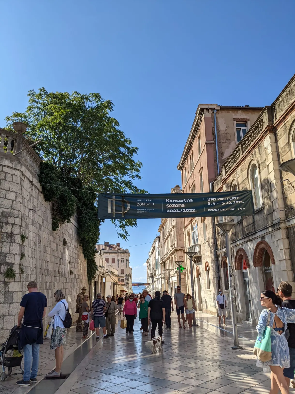 Busy shopping street between old walls and shops