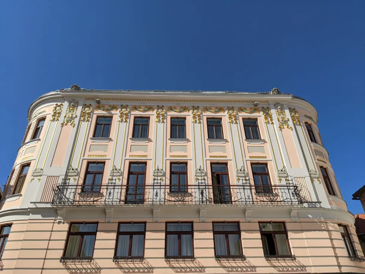 Curved neoclassical facade with wrought iron balconies