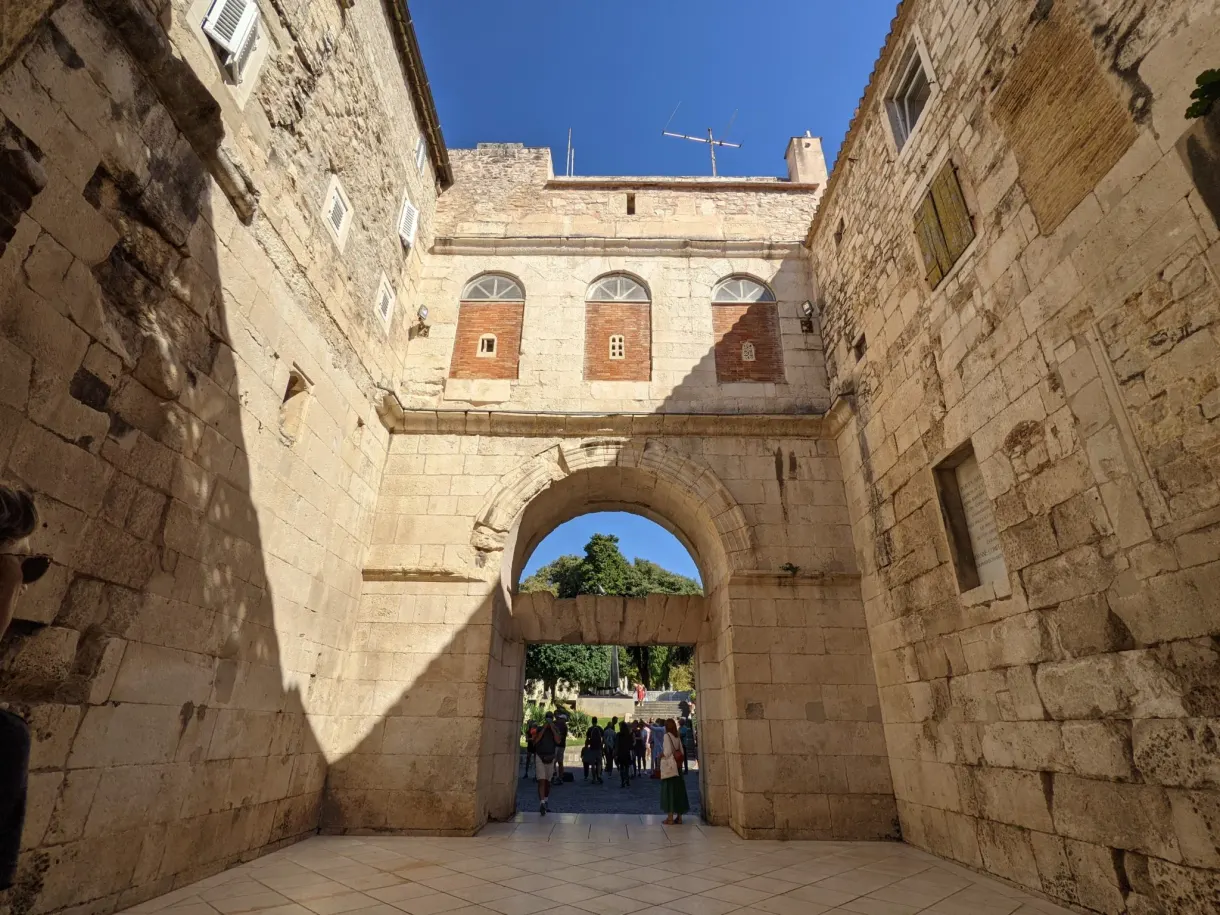 Vaulted stone passage opening onto a busy street