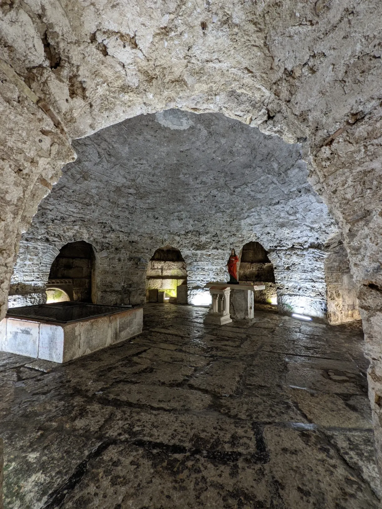 Vaulted crypt with a flagstone floor and rough stone walls