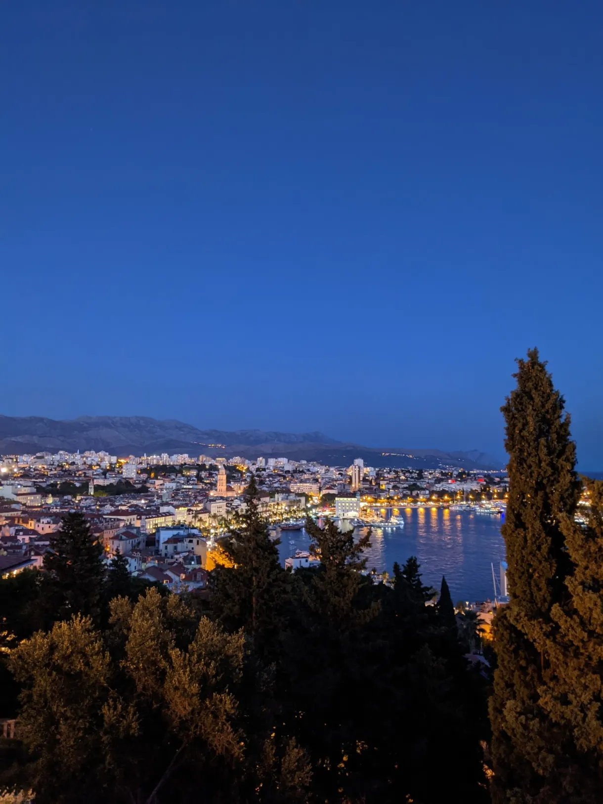 Illuminated town and gulf at nightfall