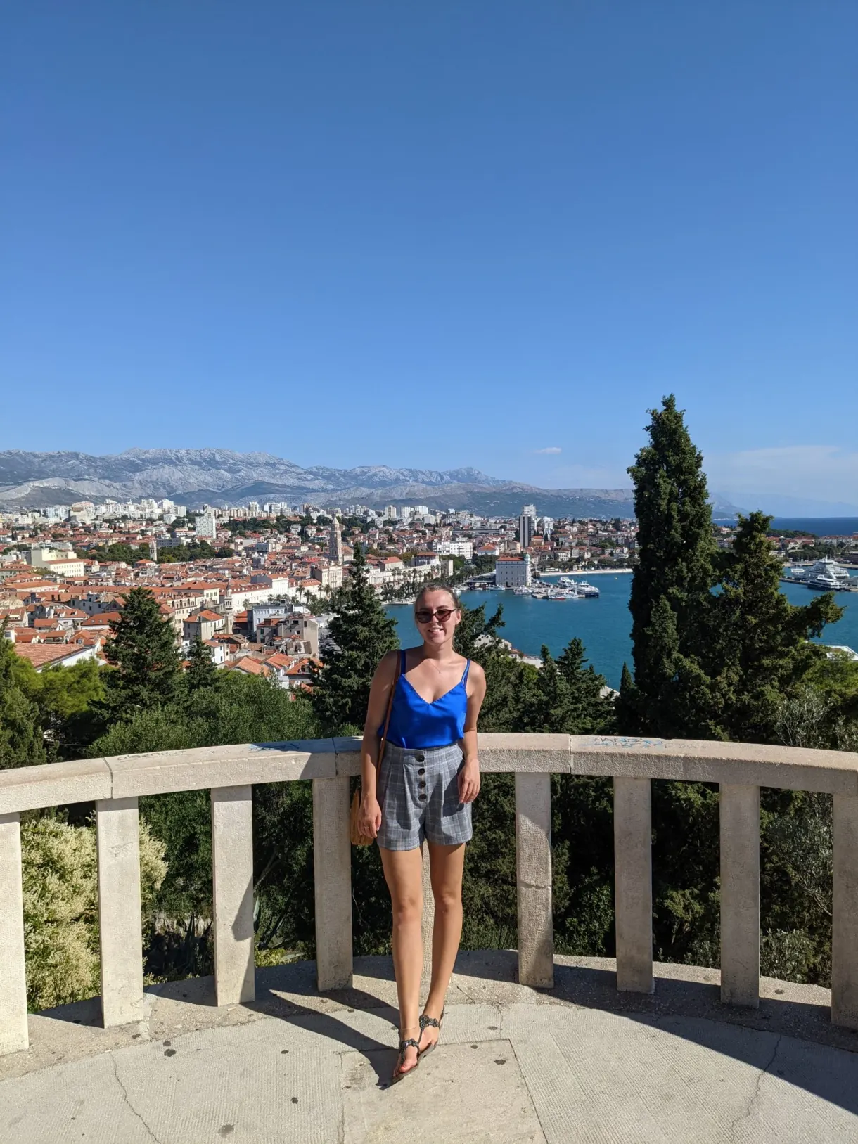 Woman leaning on a panoramic railing above the rooftops