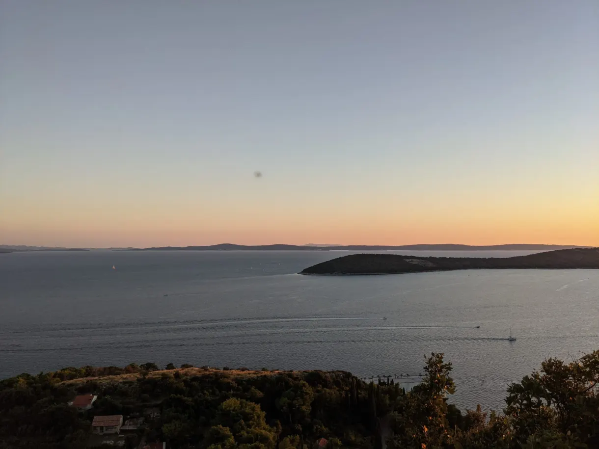 Wooded peninsula standing out against the sea at dusk