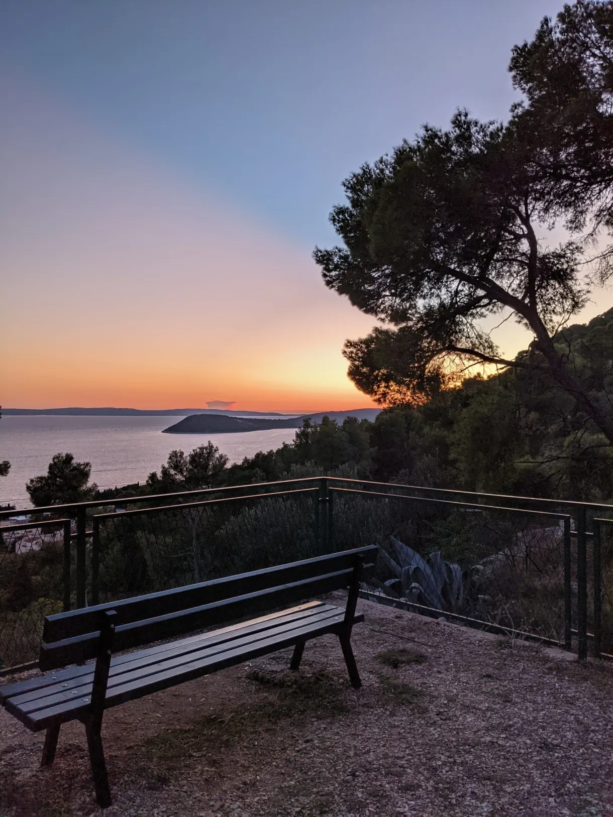 Wooden bench facing the sea at sunset