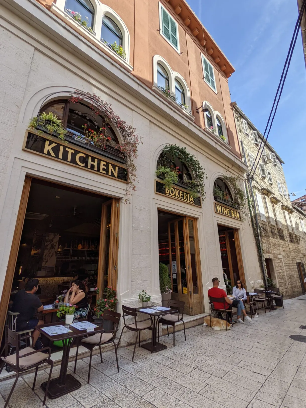 Restaurant terrace beneath an arcaded facade