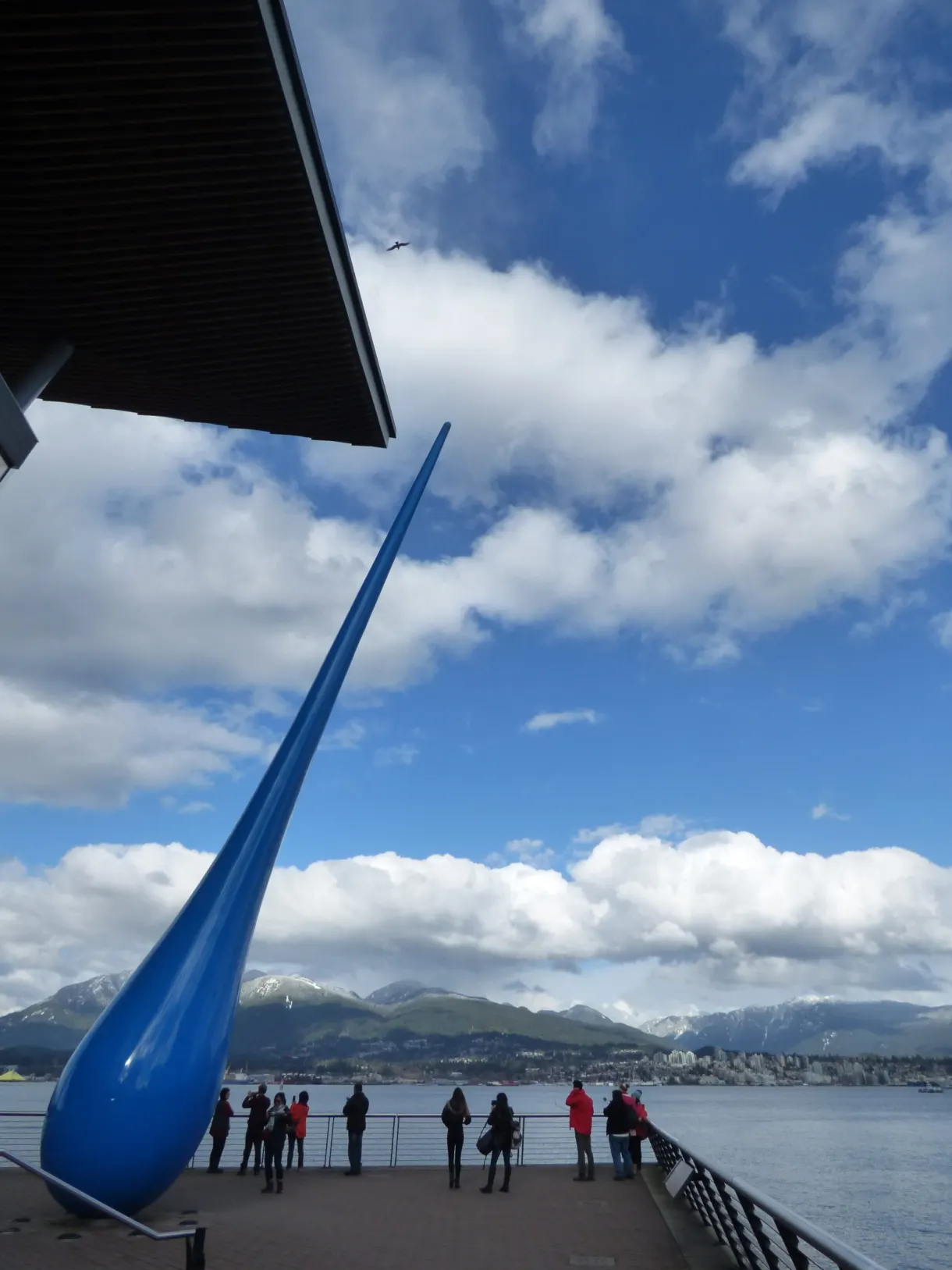 Sculpture in the shape of a giant blue drop and onlookers