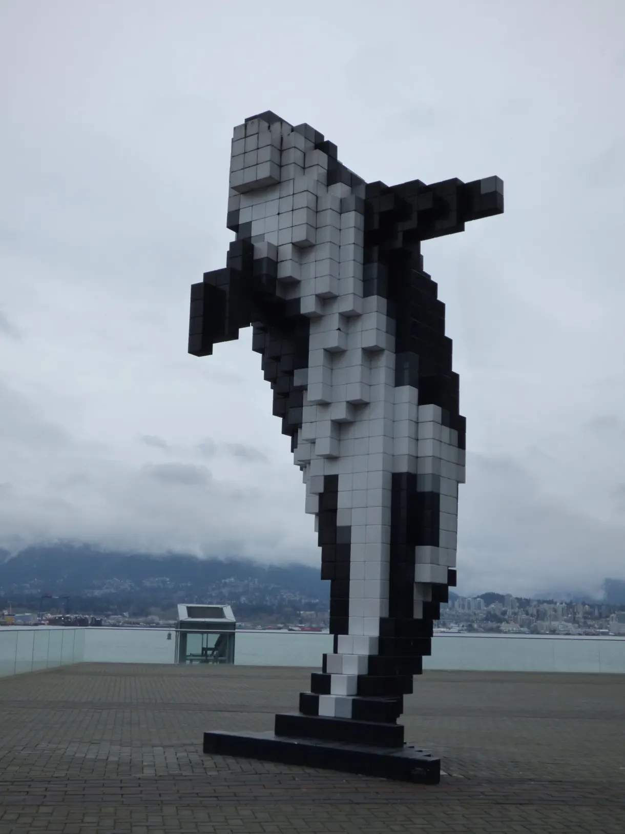 Black and white pixelated orca standing on the esplanade