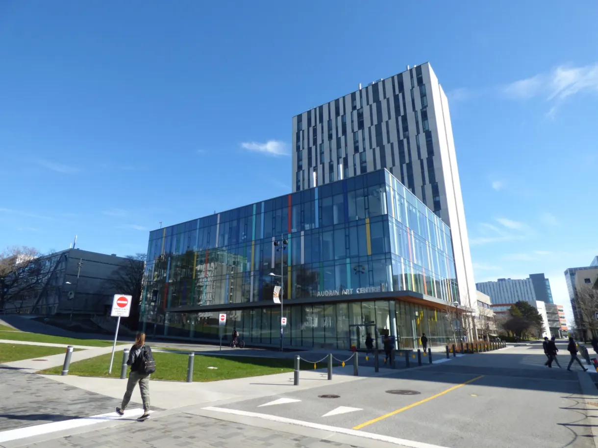 Glass campus building and a passer-by on the pavement