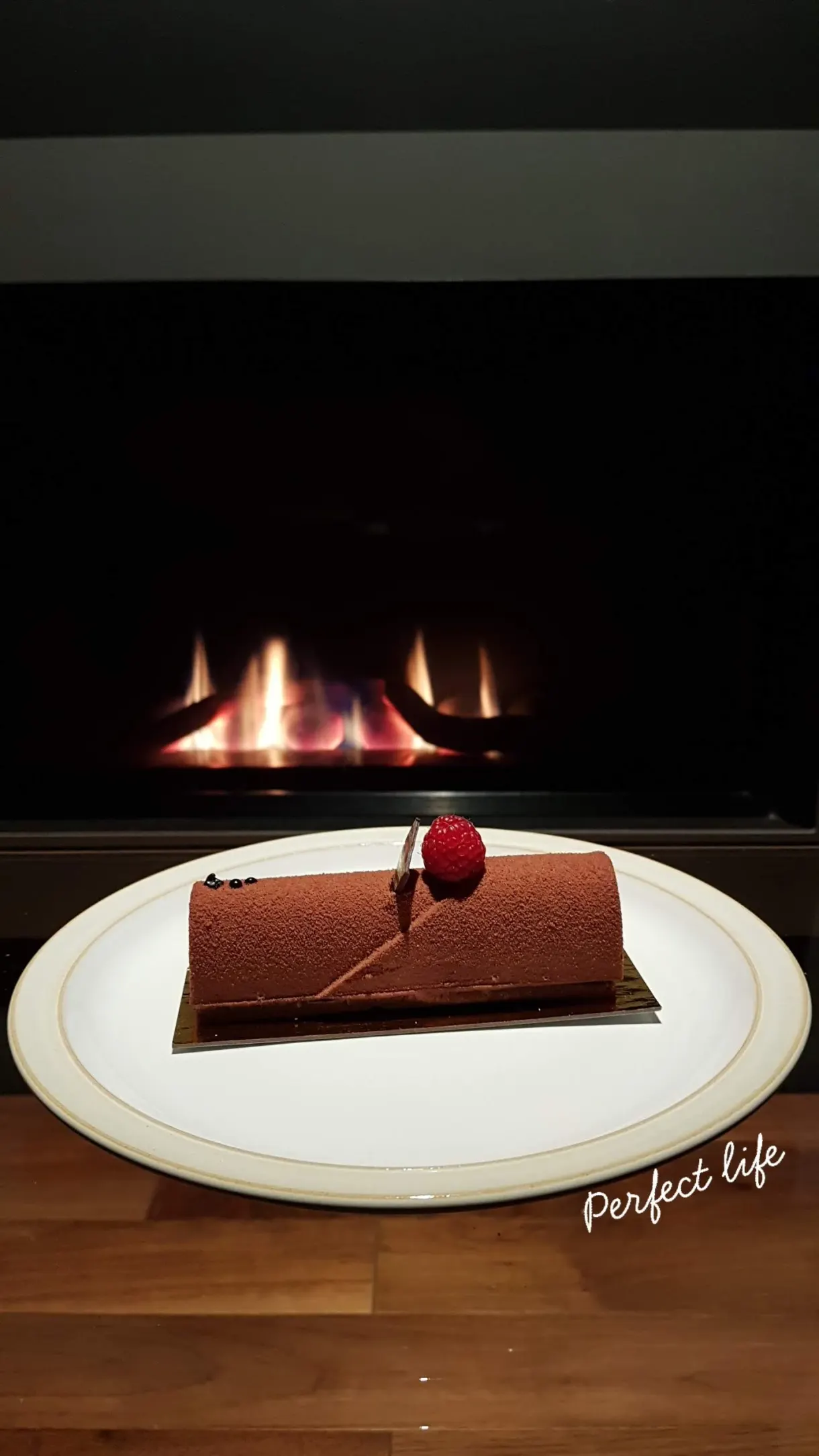 Chocolate dessert plated in front of a lit fireplace