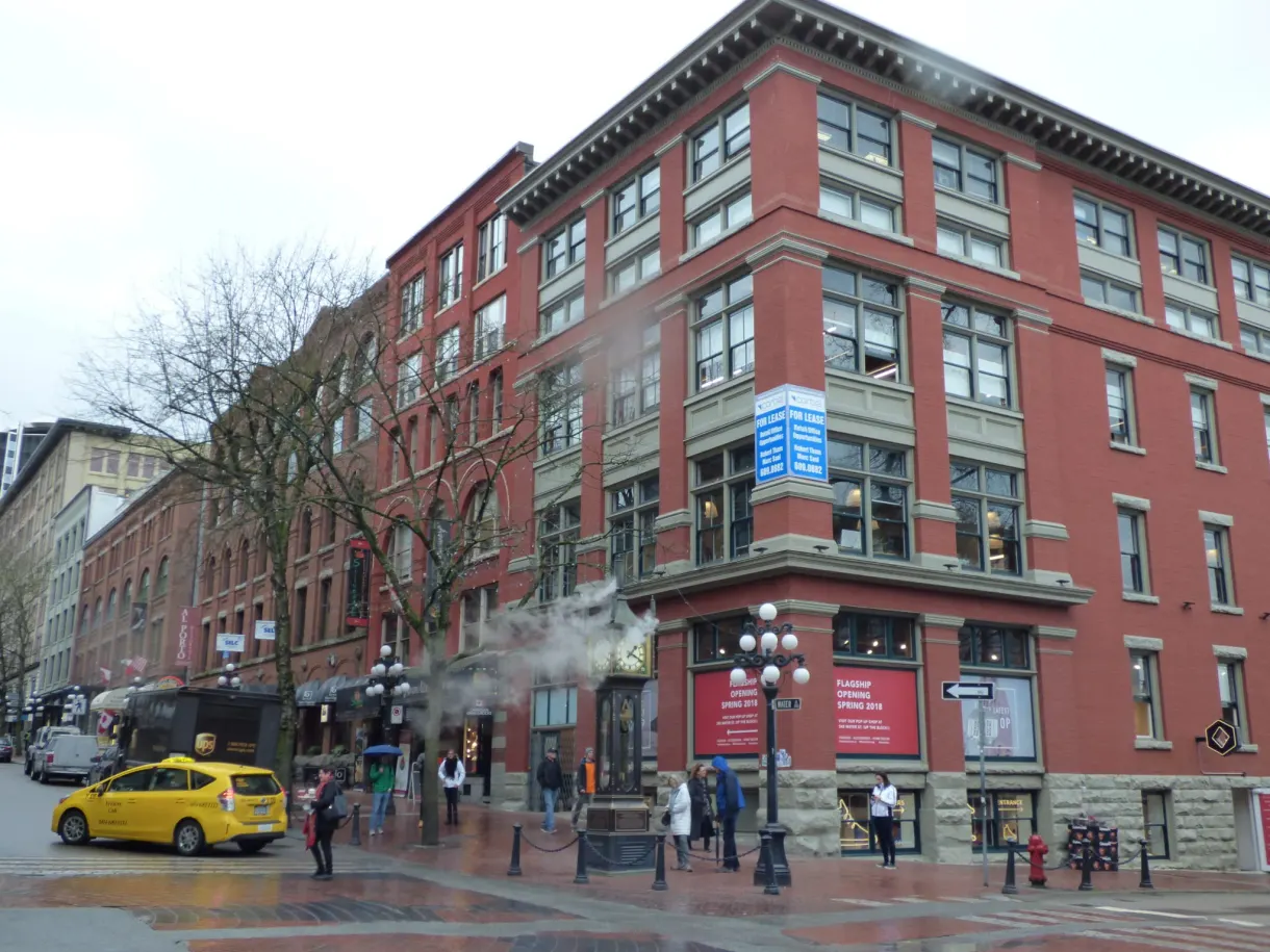Red brick corner building and yellow taxi