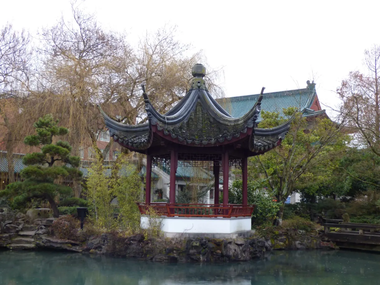 Pavilion with curved tiles reflected in the turquoise water