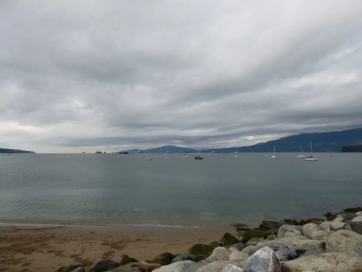 Sailing boats at anchor under a sky of low clouds