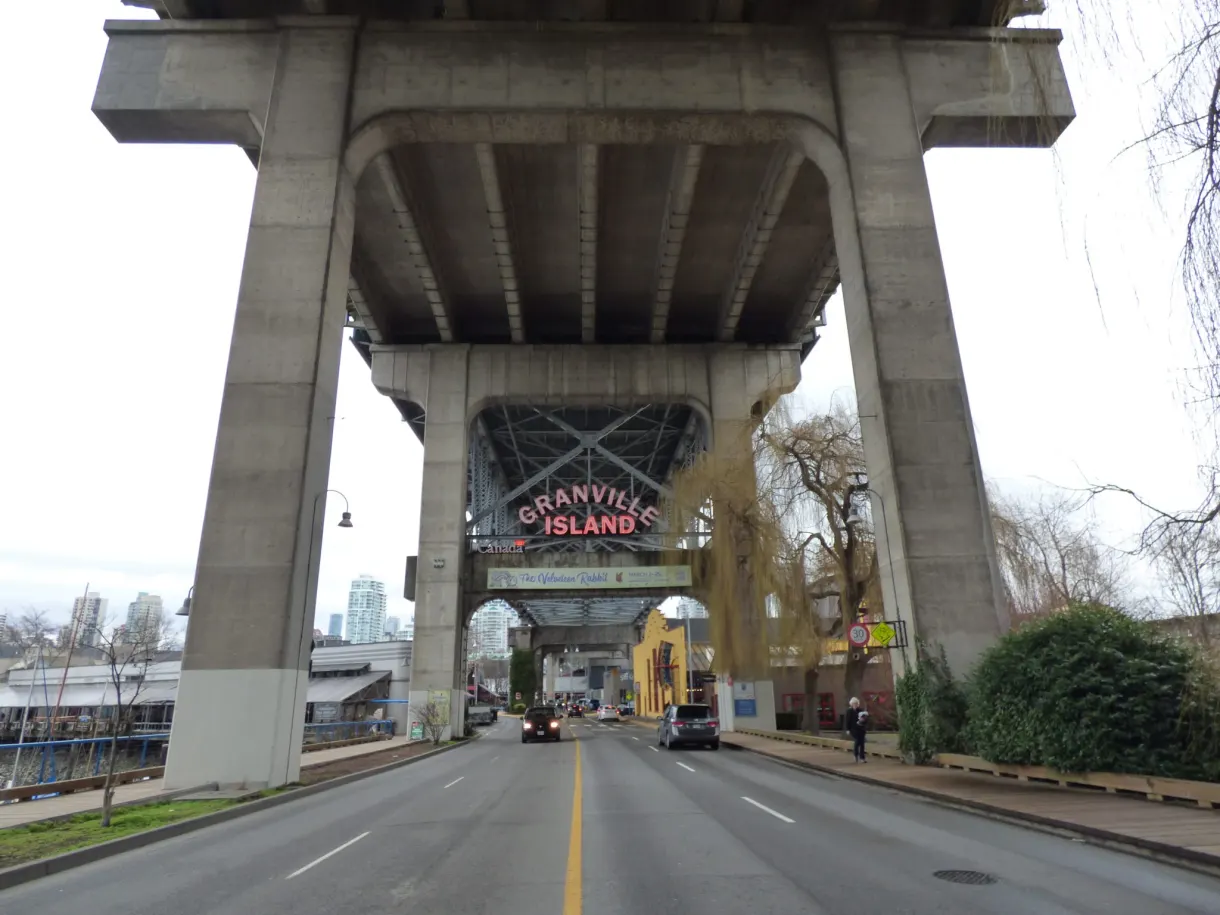 Road passing under the piers of the bridge towards Granville Island
