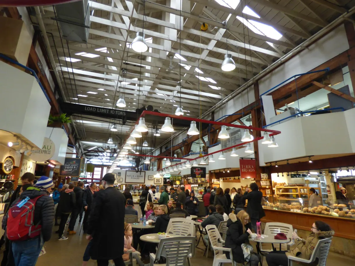Crowd and stalls under the roof frame of the public market