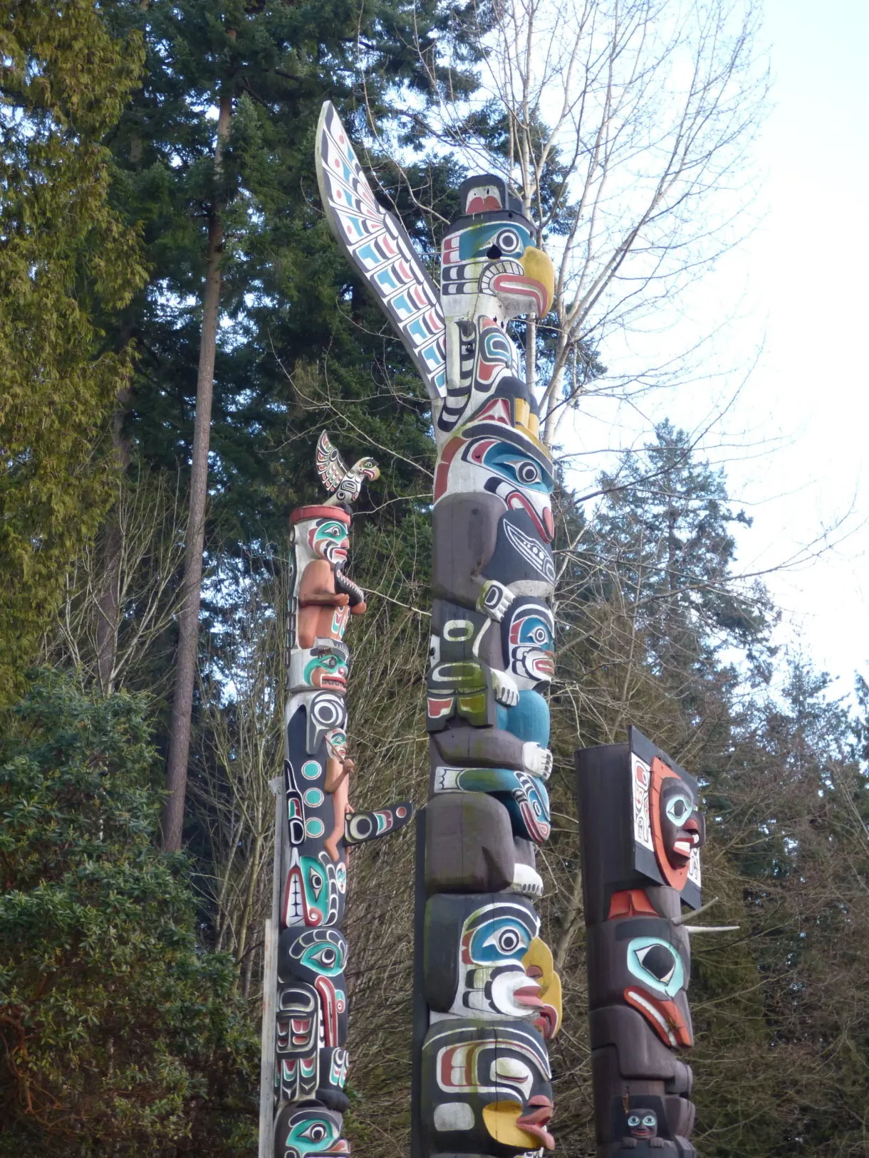 Low-angle view of totem poles, carved eagle at the top