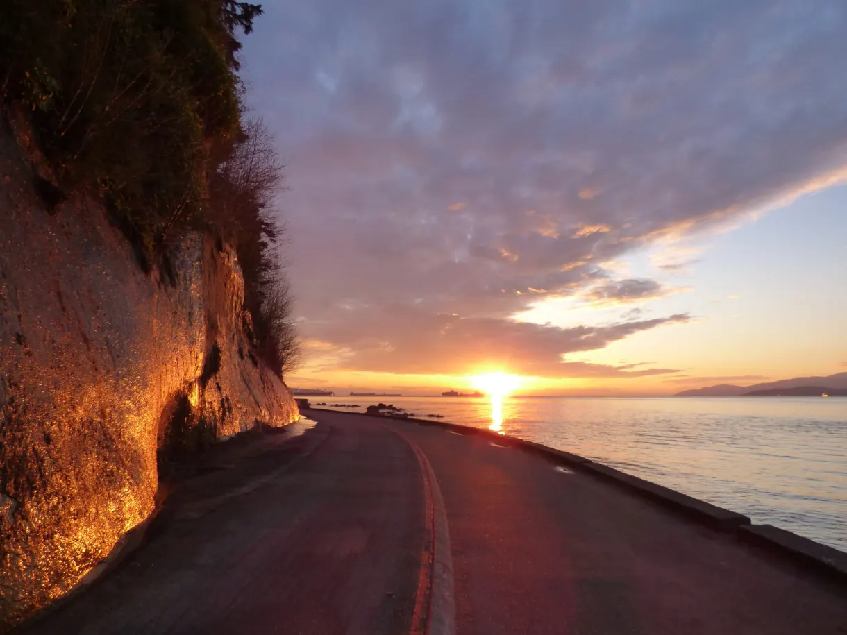 Russet cliff and curving road under an orange sky